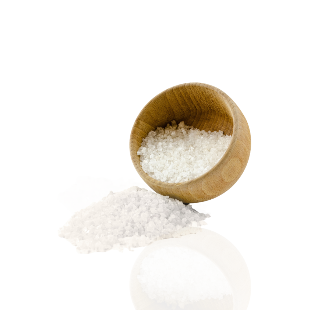 Wooden bowl filled with coarse salt, some spilled on the surface.