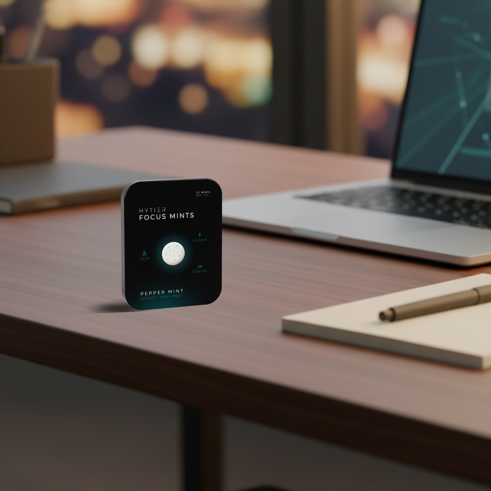 Tin of focus mints on an office desk with laptop and pen.