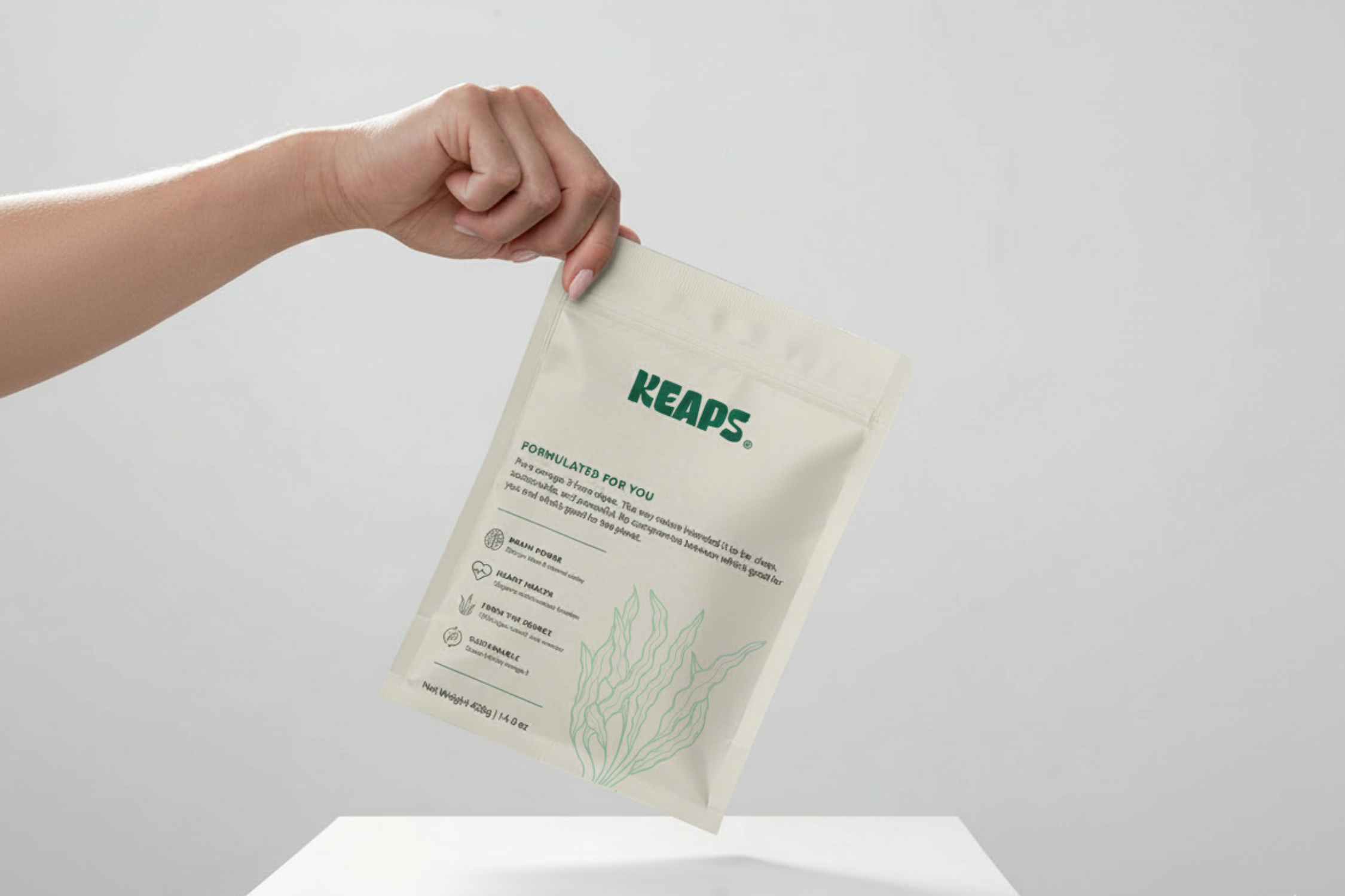 Hand holding a beige Keaps branded pouch with text and icons.