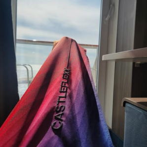 Customer photo of a sunset-colored CastleFlexx strap around a foot by a window