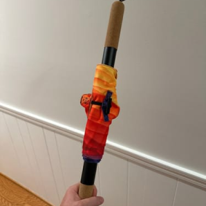 Customer photo of an orange and red CastleFlexx strap held up by its cork handle