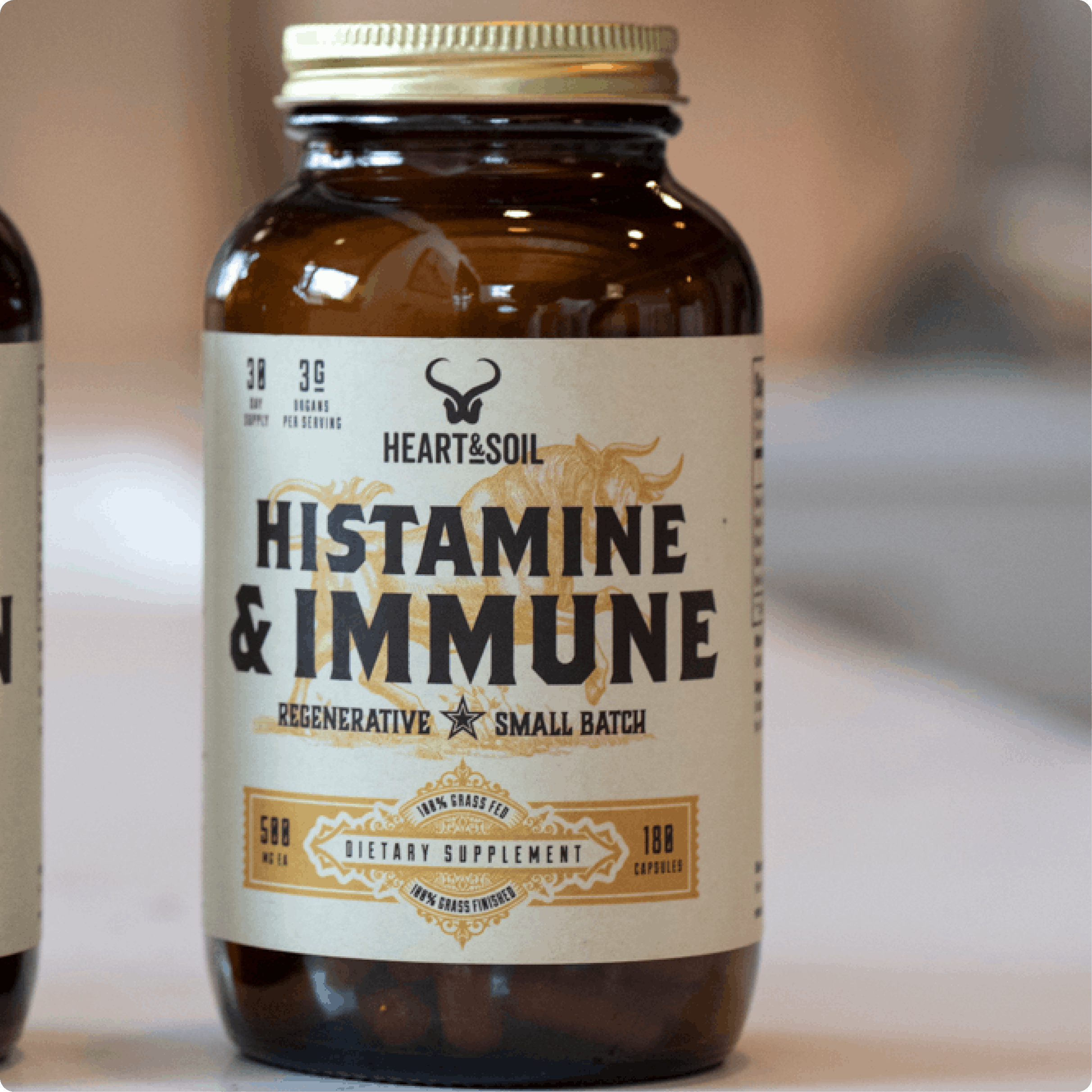 A brown glass bottle of Heart & Soil Histamine & Immune dietary supplement against a blurred background.