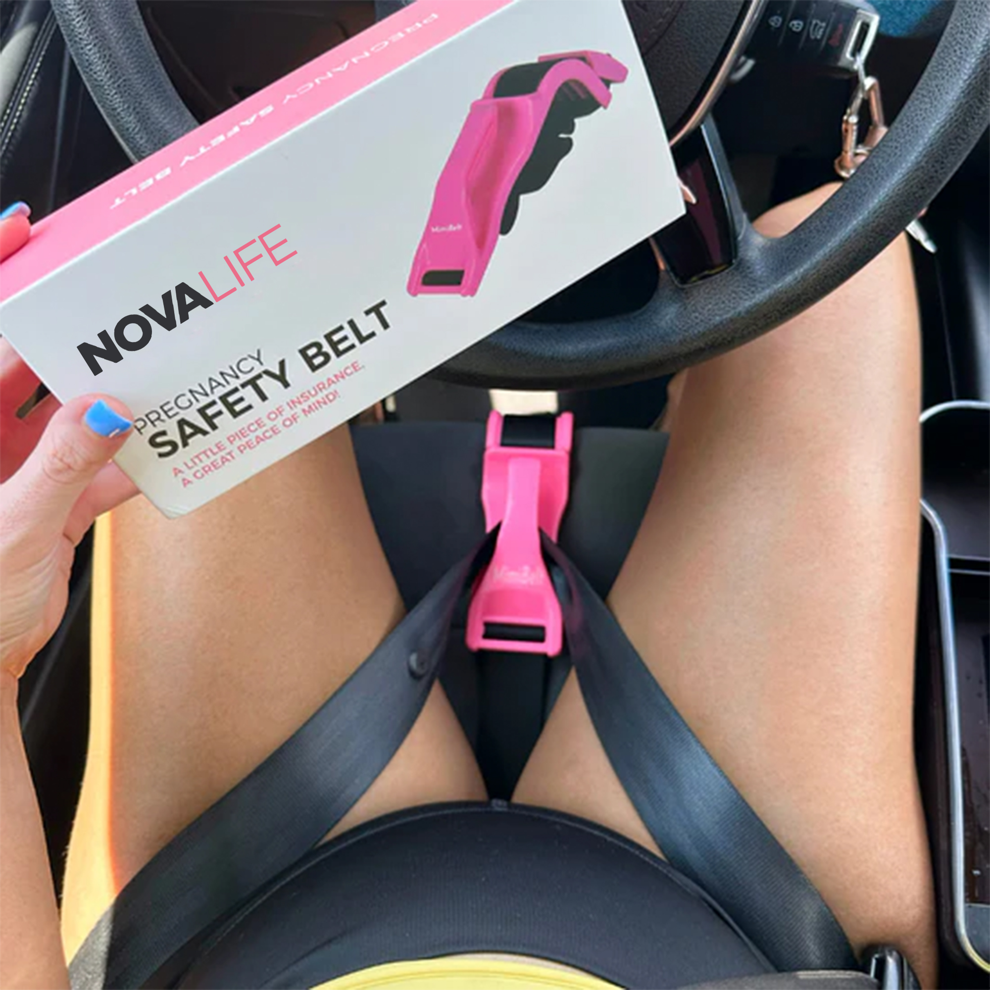 Pregnancy safety belt box held over a pregnant belly in a car.