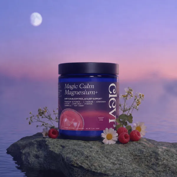 A jar of Clevr Magic Calm Magnesium+ supplement sits on a rock surrounded by white daisies and fresh raspberries against a twilight sky with a moon.