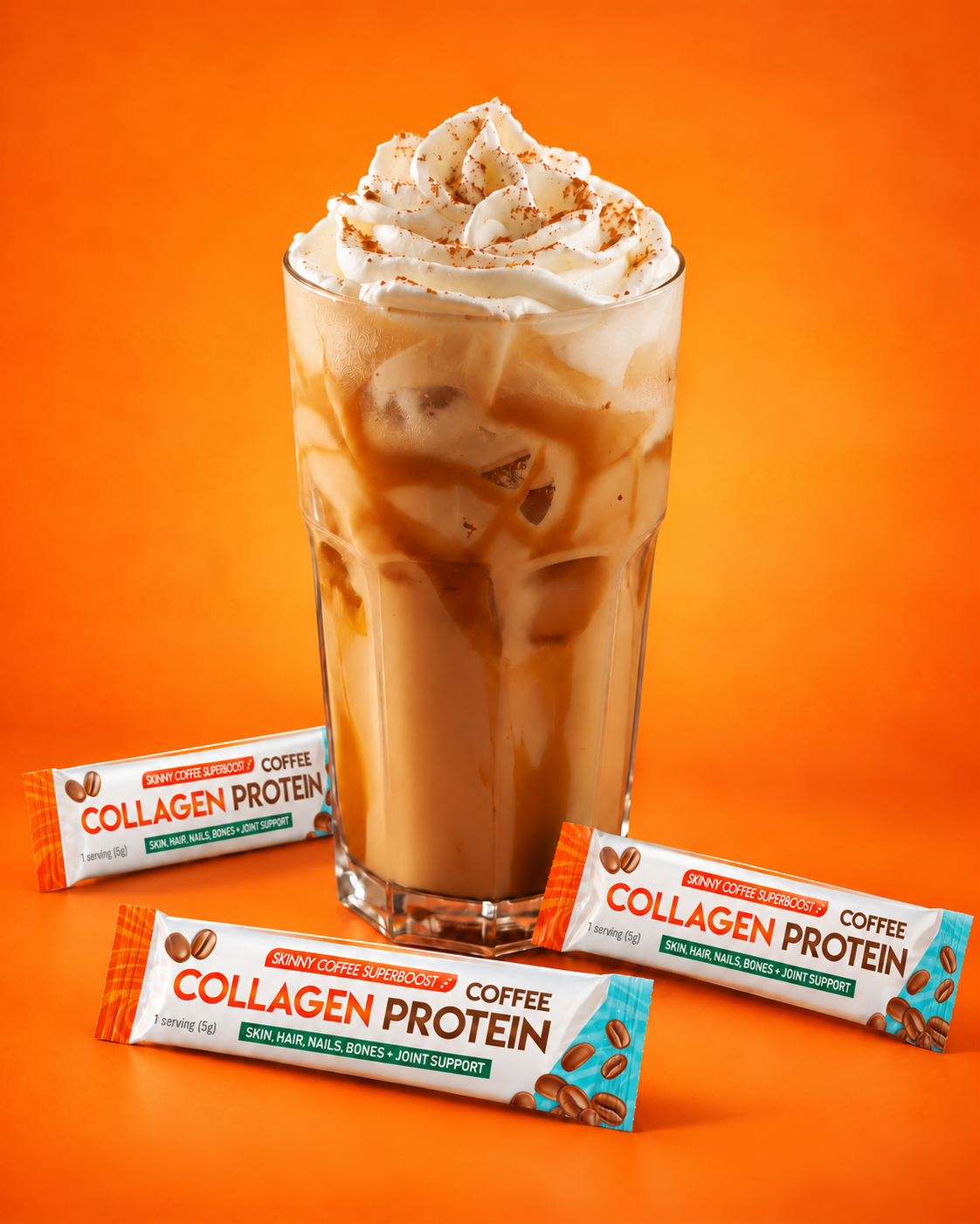 A glass of iced coffee with whipped cream and caramel, next to three packets of coffee collagen protein.