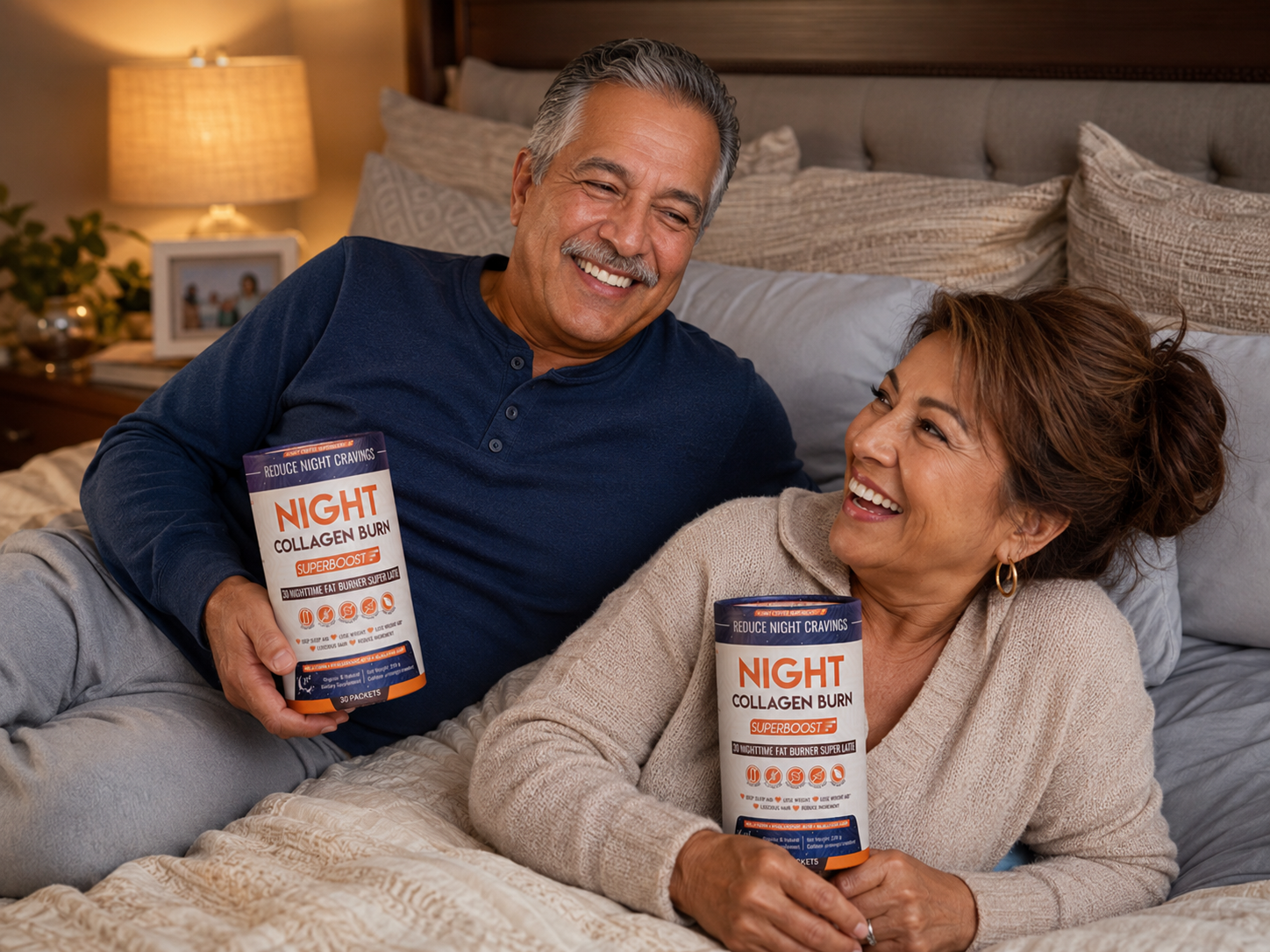 A smiling man and woman relax on a bed, each holding a container of Night Collagen Burn.