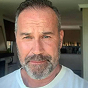 A headshot of a middle-aged man with a short beard and graying hair, looking at the camera.