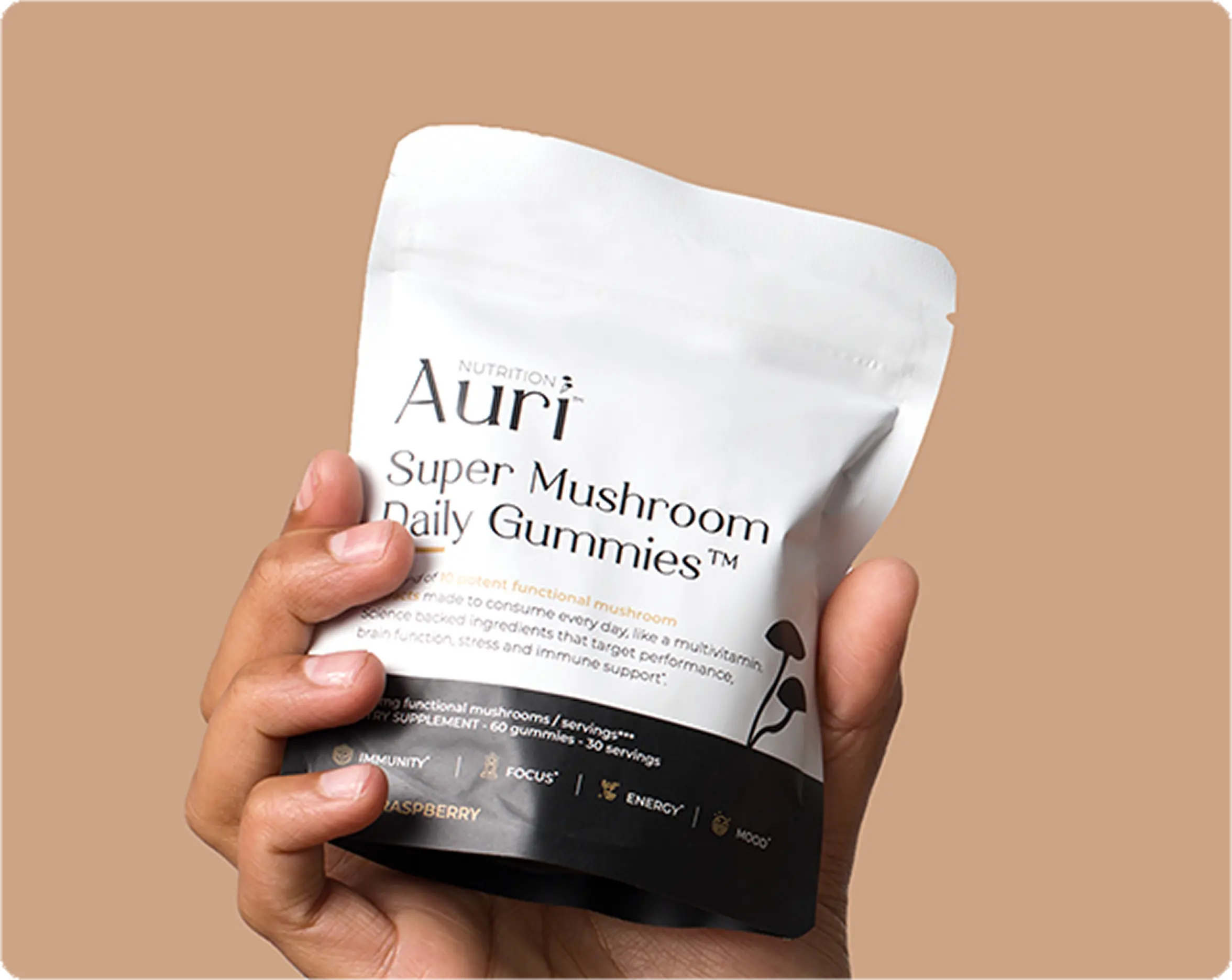 Hand holding a package of Auri Super Mushroom Daily Gummies.