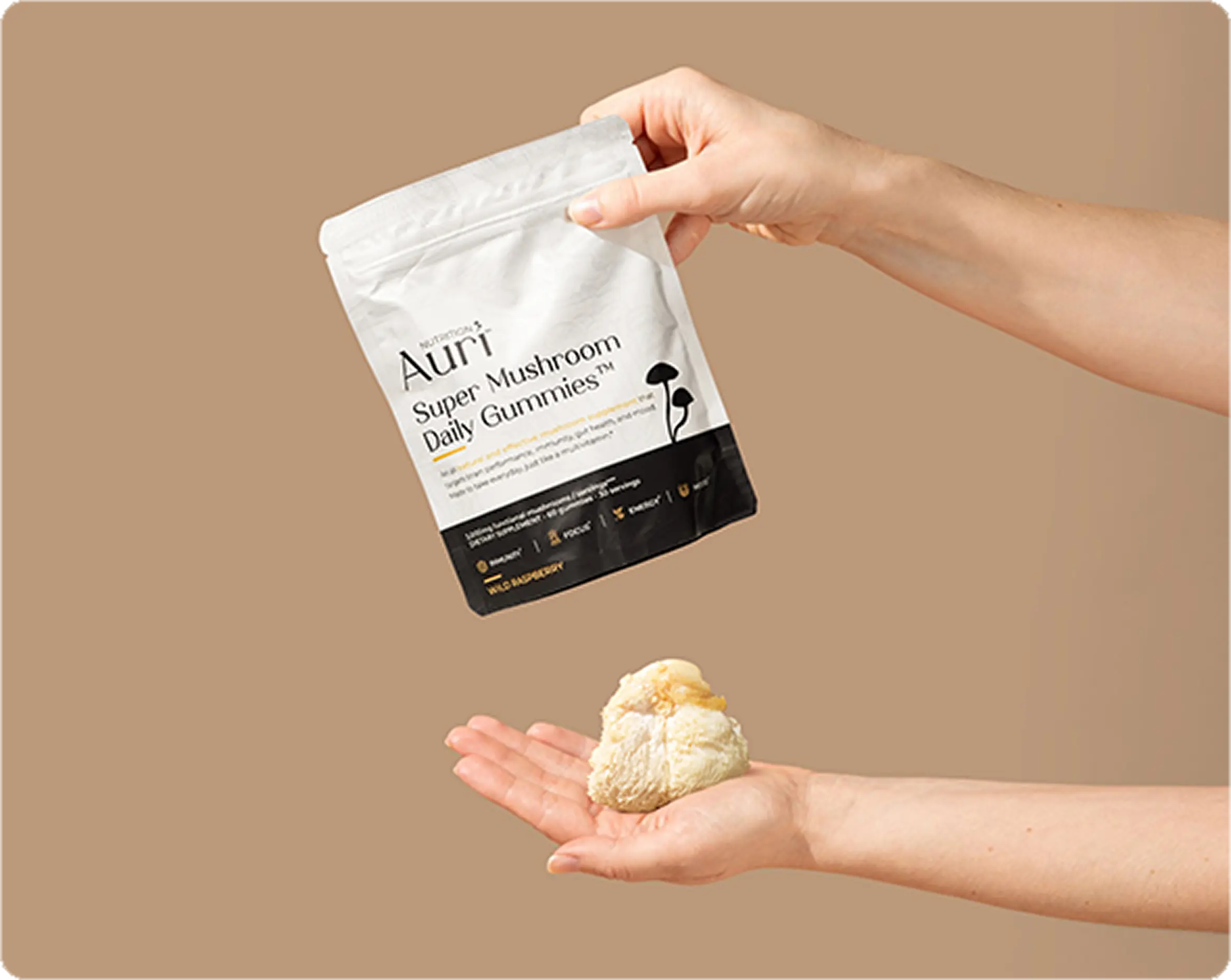 Hands holding a bag of mushroom gummies and a mushroom on a beige background.