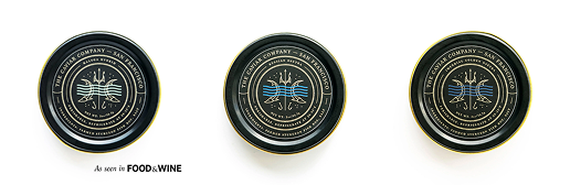 Three black and gold tins of caviar from The Caviar Company against a white background.