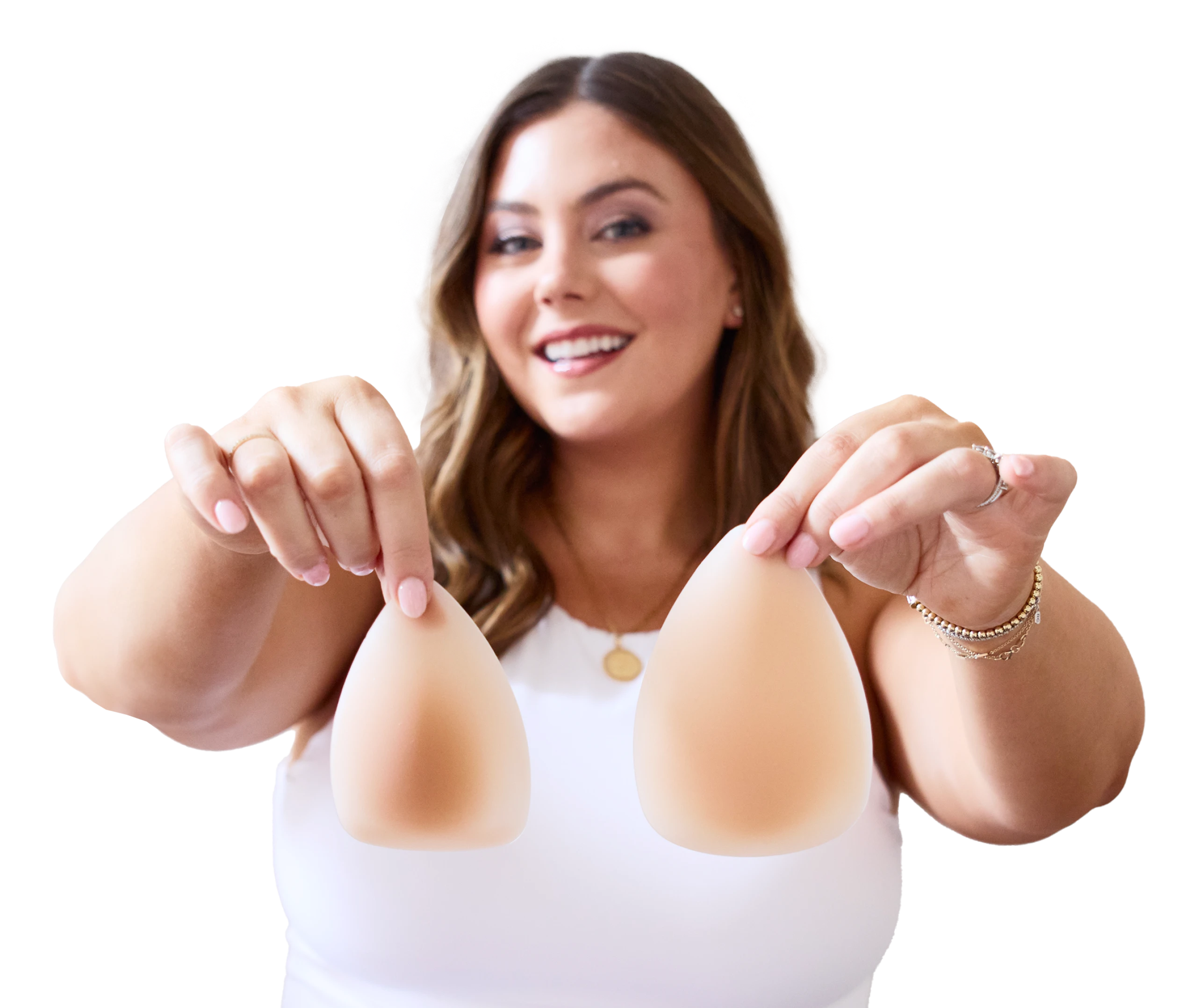 Woman holding two silicone breast forms, smiling.
