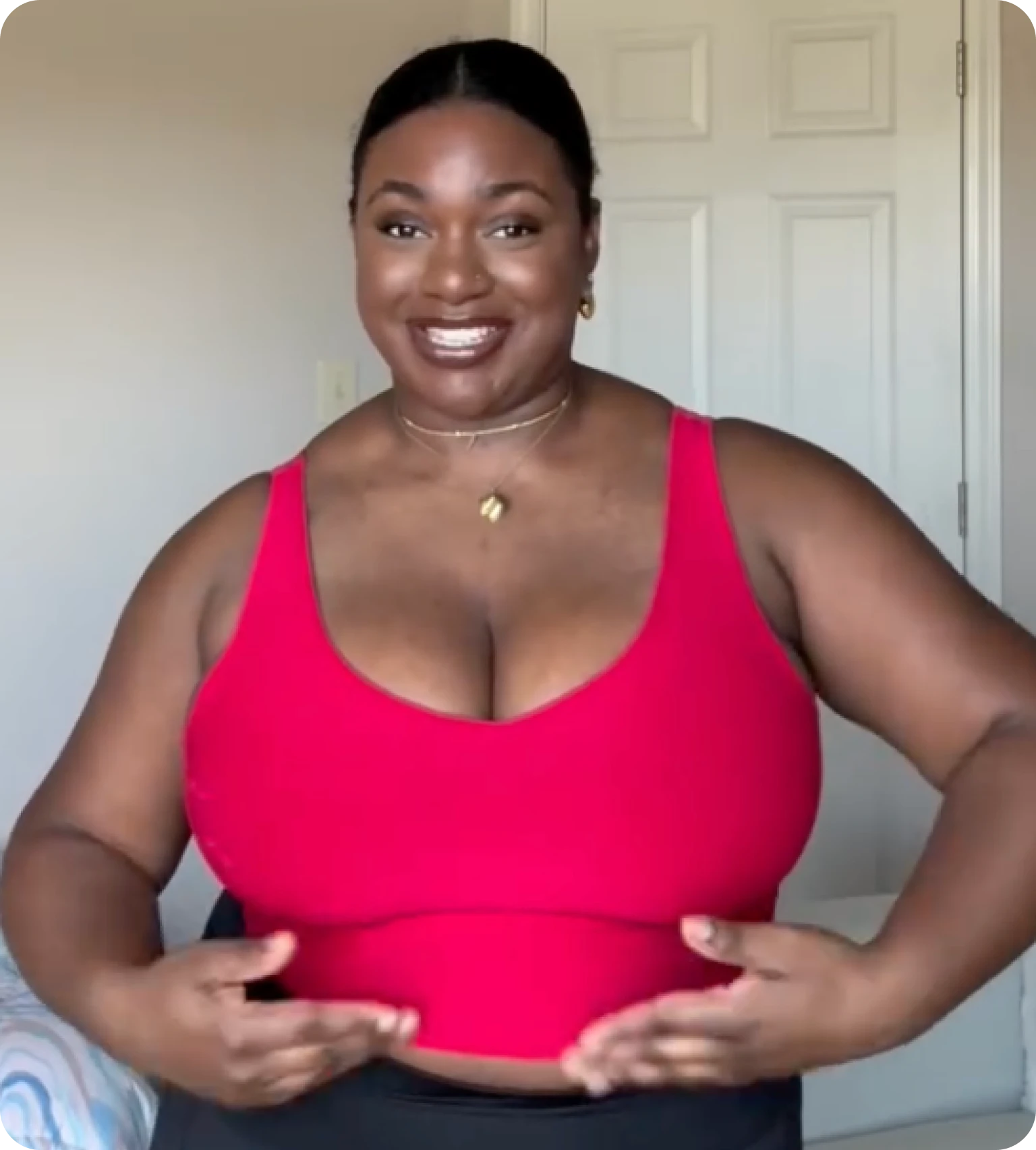 Smiling person in a red top with a neutral background.