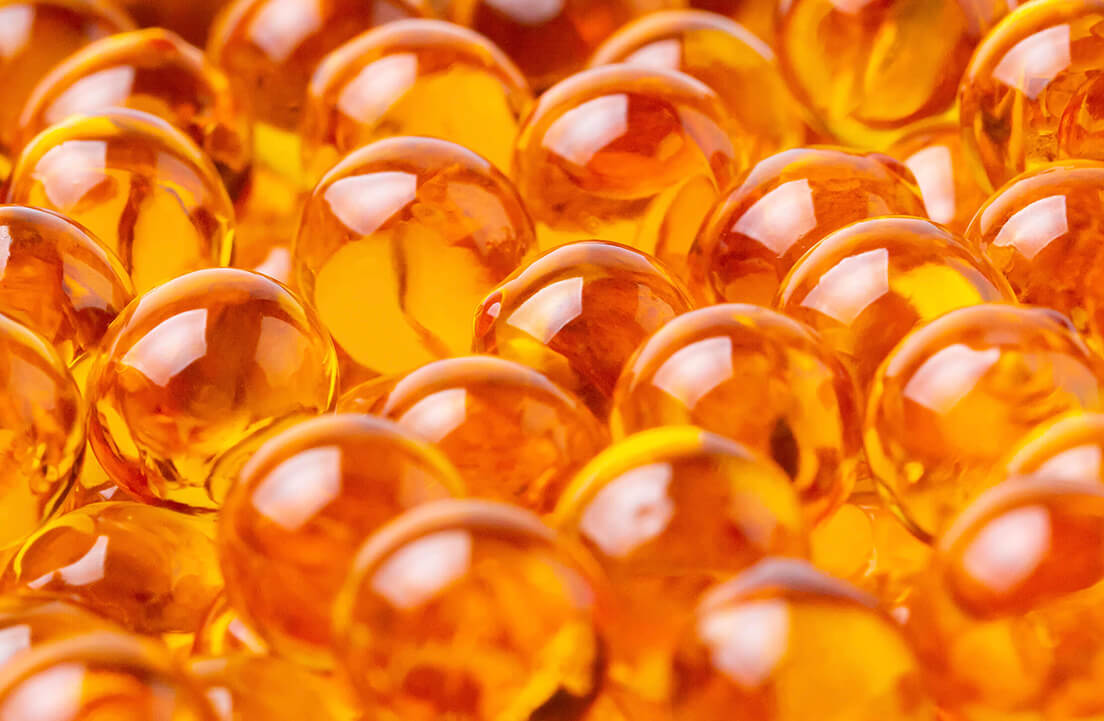 Close-up of shiny orange gel capsules.