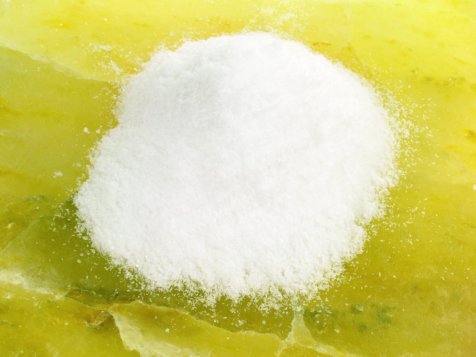 A pile of white powder on a yellow surface.