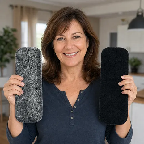 A smiling woman holds up a grey textured rectangular pad and a black rectangular pad.