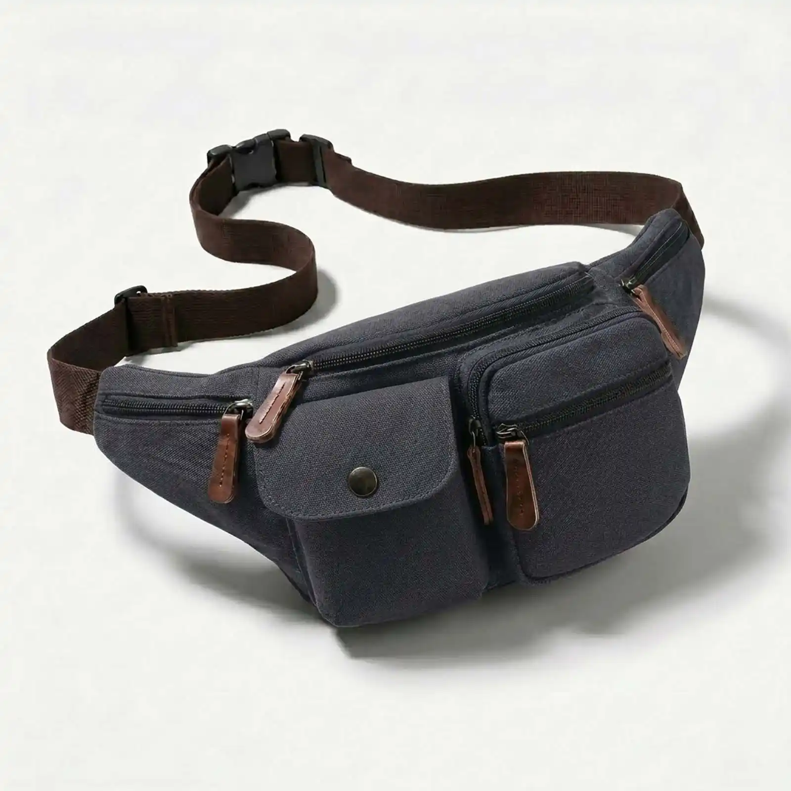 A dark gray canvas fanny pack with multiple pockets and a brown strap on a white background.