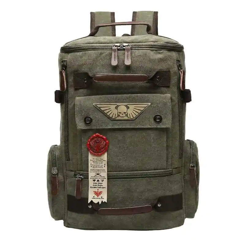 An olive green canvas backpack with brown leather accents and a winged skull emblem on the front pocket.