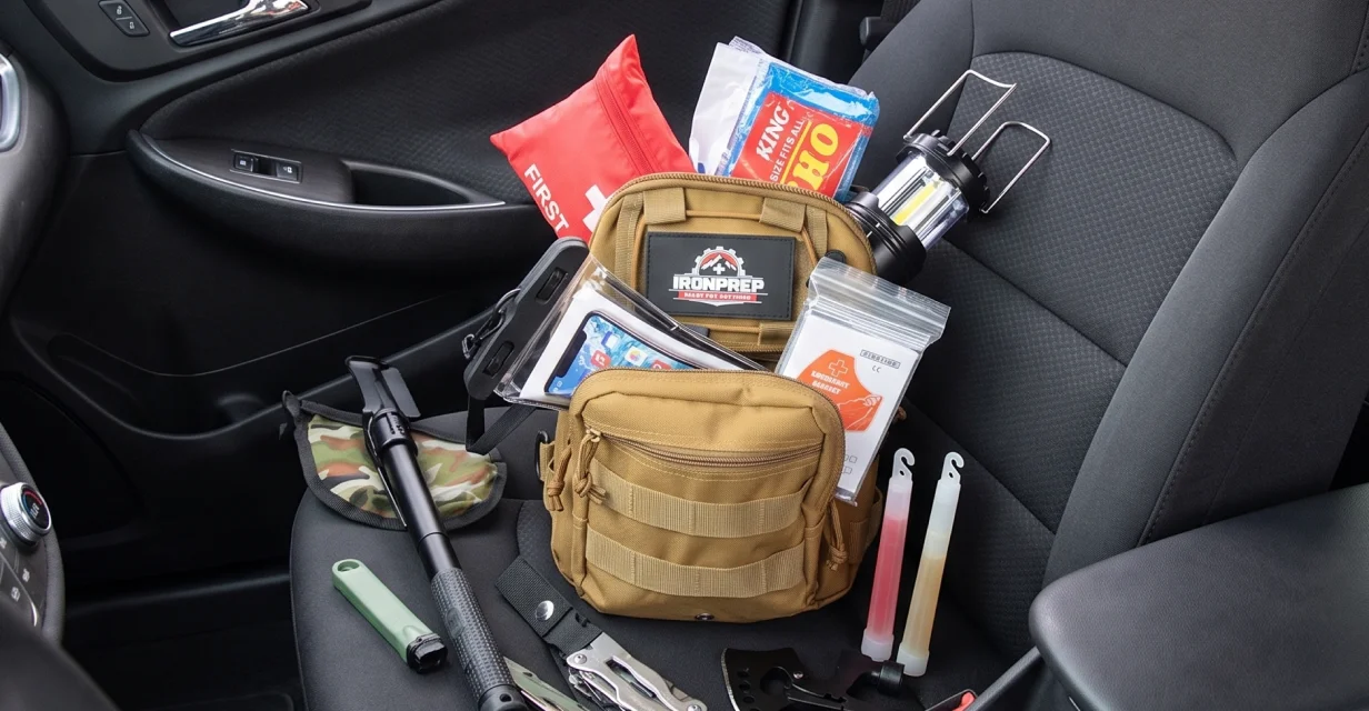 An emergency preparedness kit with various survival tools and supplies displayed on a car's passenger seat.