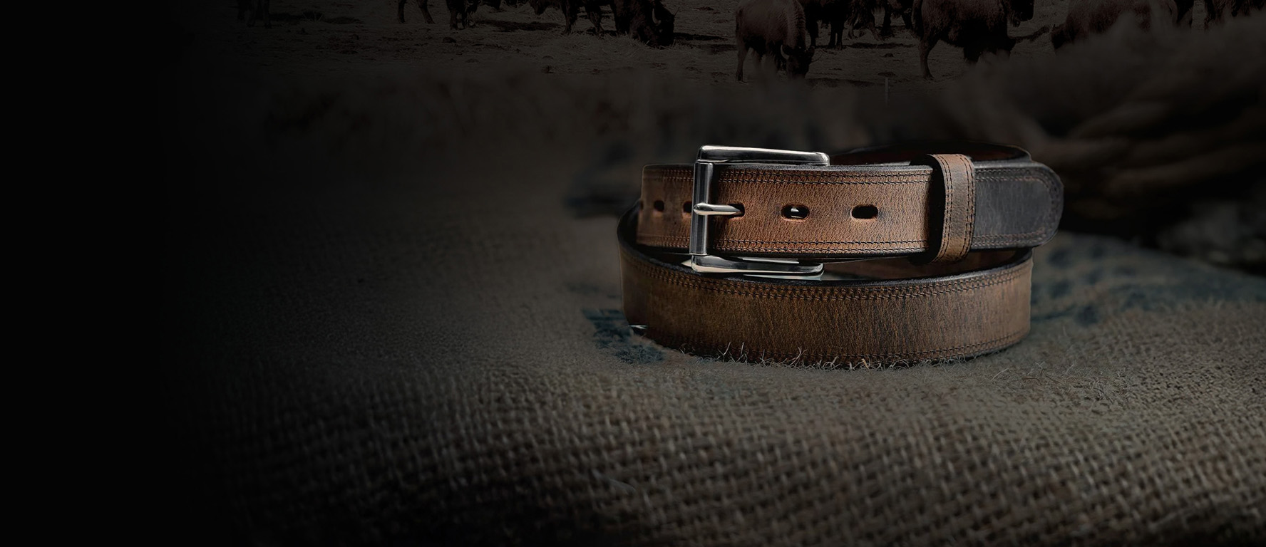 Brown leather belt on textured fabric background.