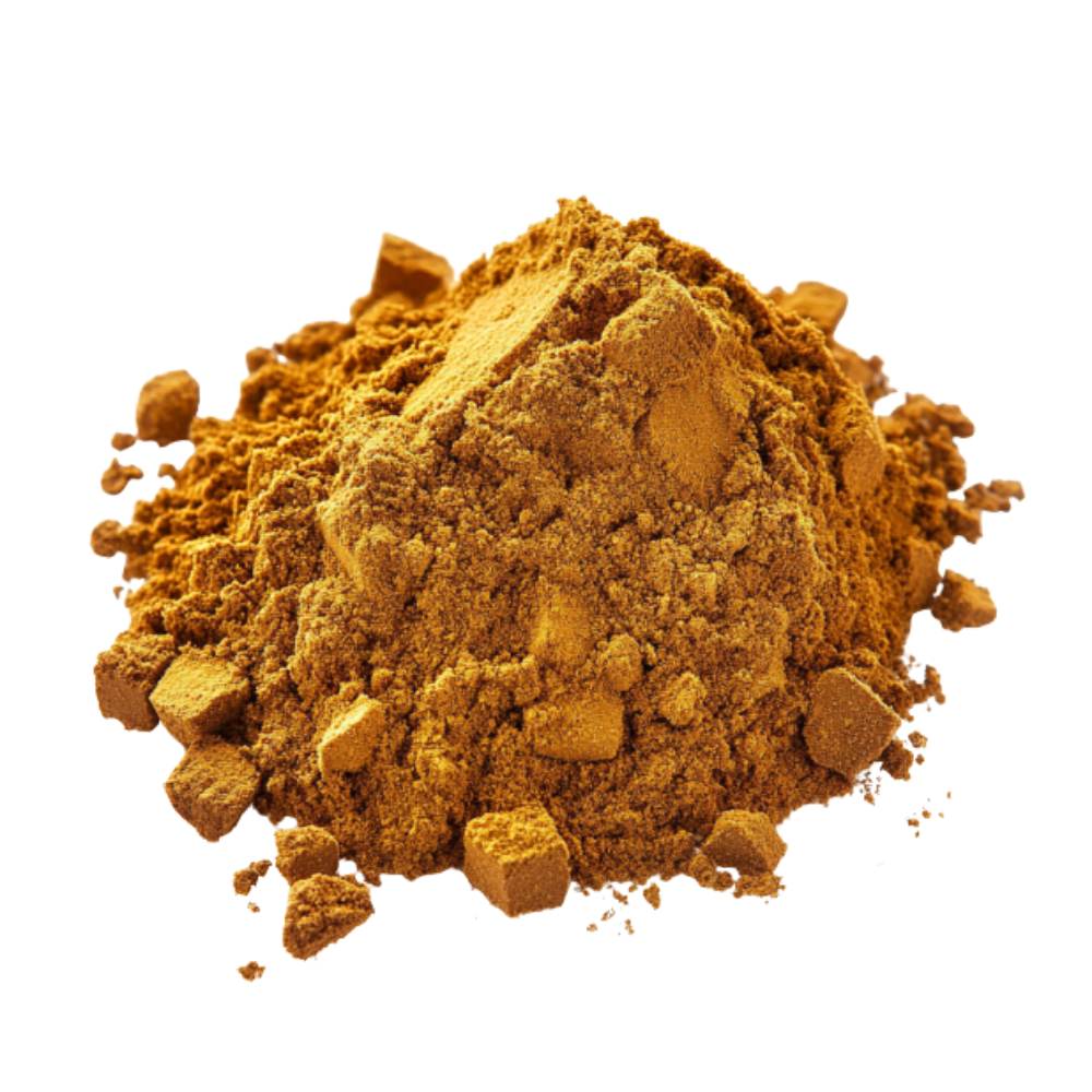 A pile of golden-brown powder with small clumps and cubes, shown against a dark green background.