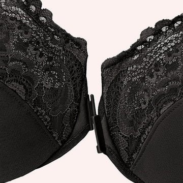 A close-up of a black lace bra with a front-clasp closure against a light background.