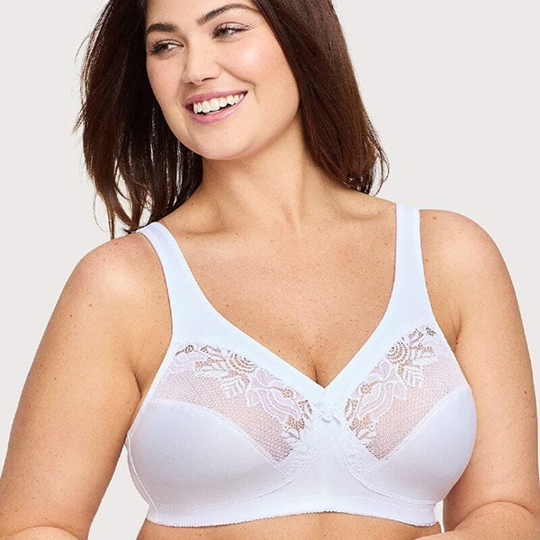 A smiling woman with brown hair models a white bra with lace details.