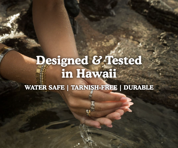 Hands with jewelry in water, text overlay about design in Hawaii.
