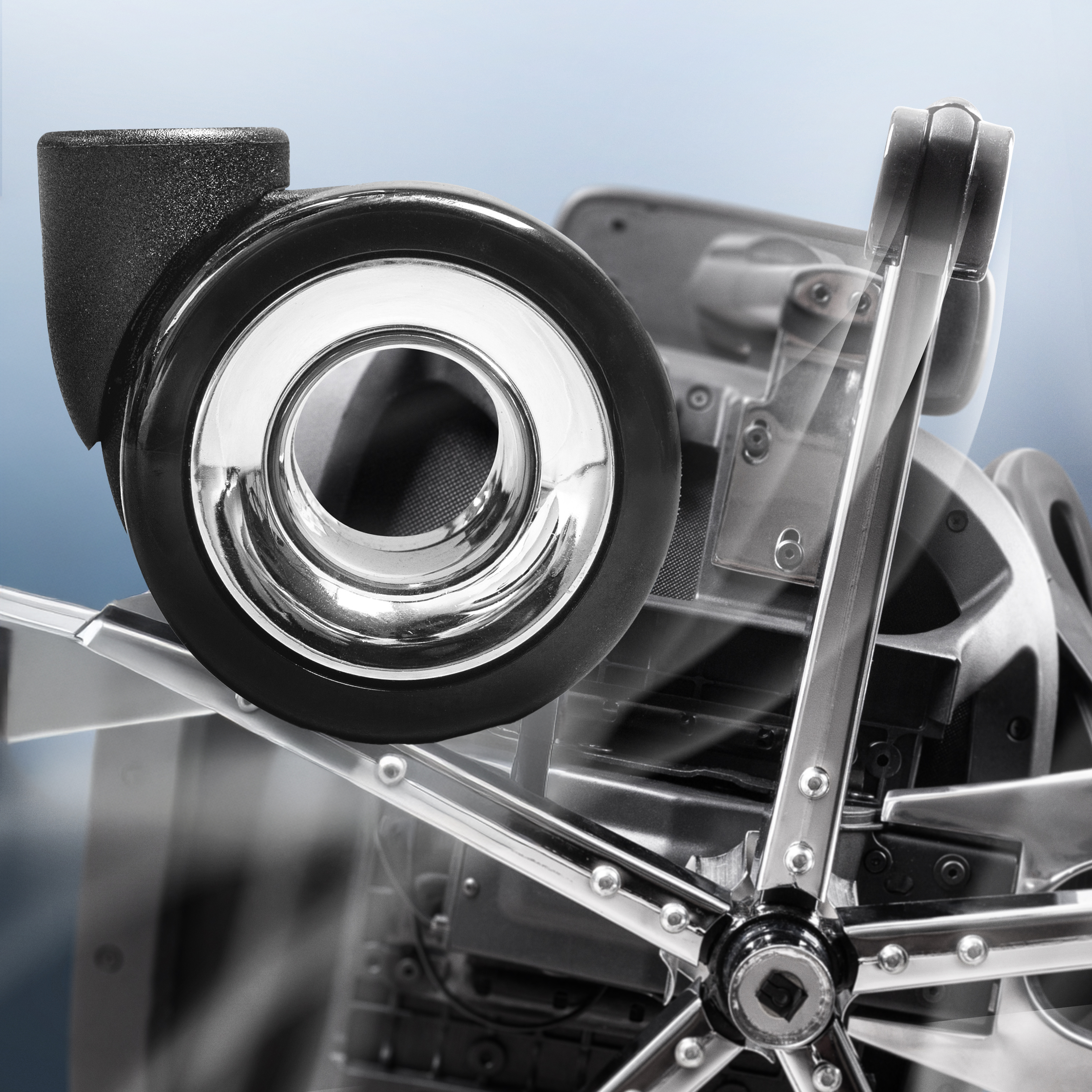 Close-up of a shiny metal and plastic wheel with spokes on a mechanical device.