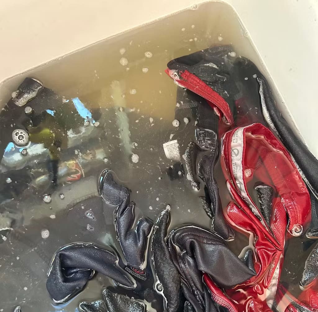 Clothes soaking in soapy water inside a container.