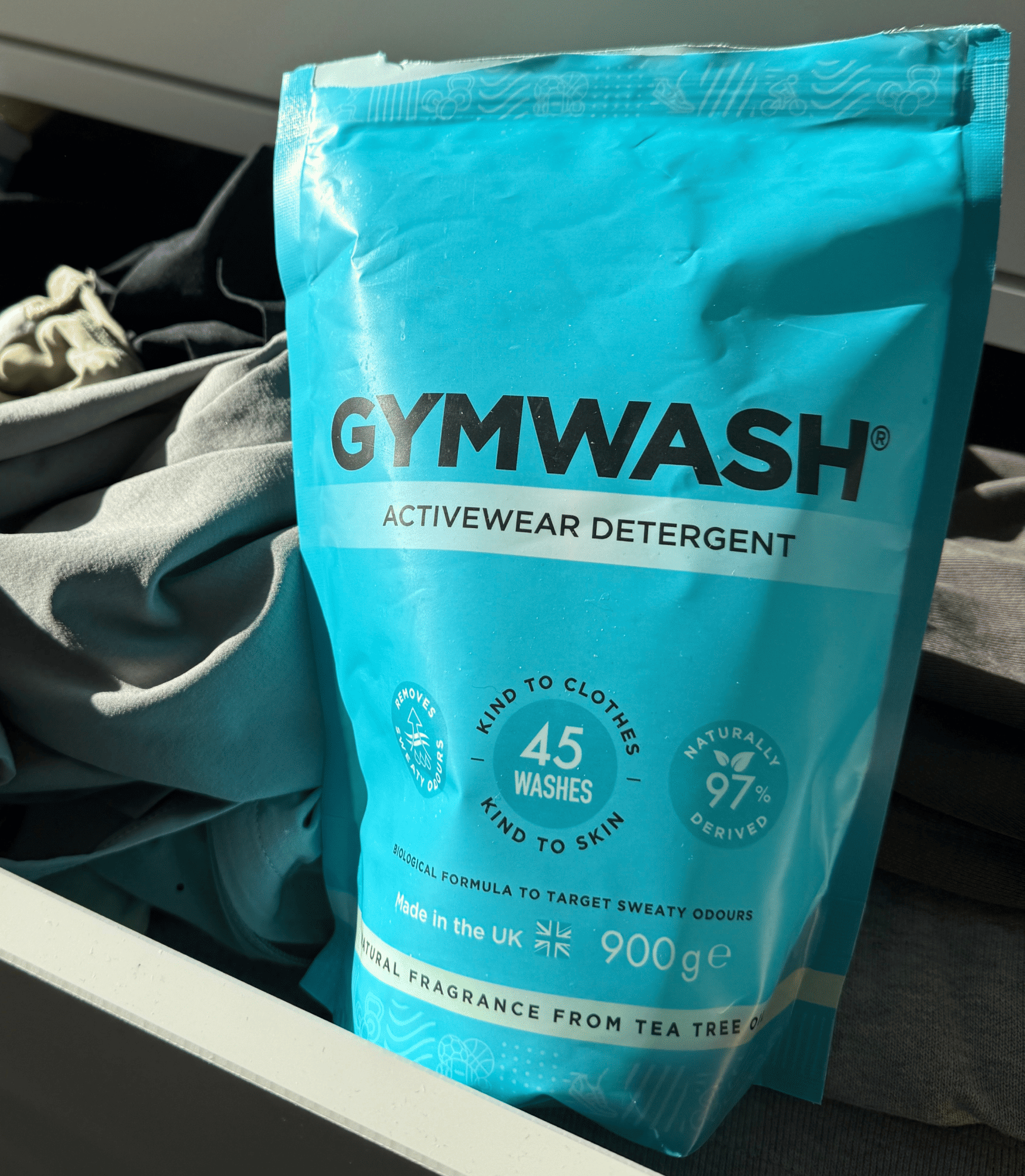 Blue Gymwash detergent bag in a drawer with clothes.