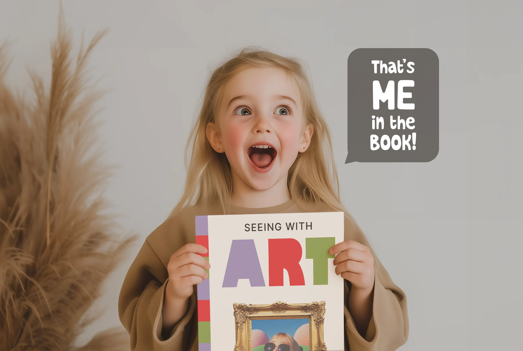 Child holding an art book, excitedly pointing to a picture, with speech bubble saying 'That's ME in the book!'