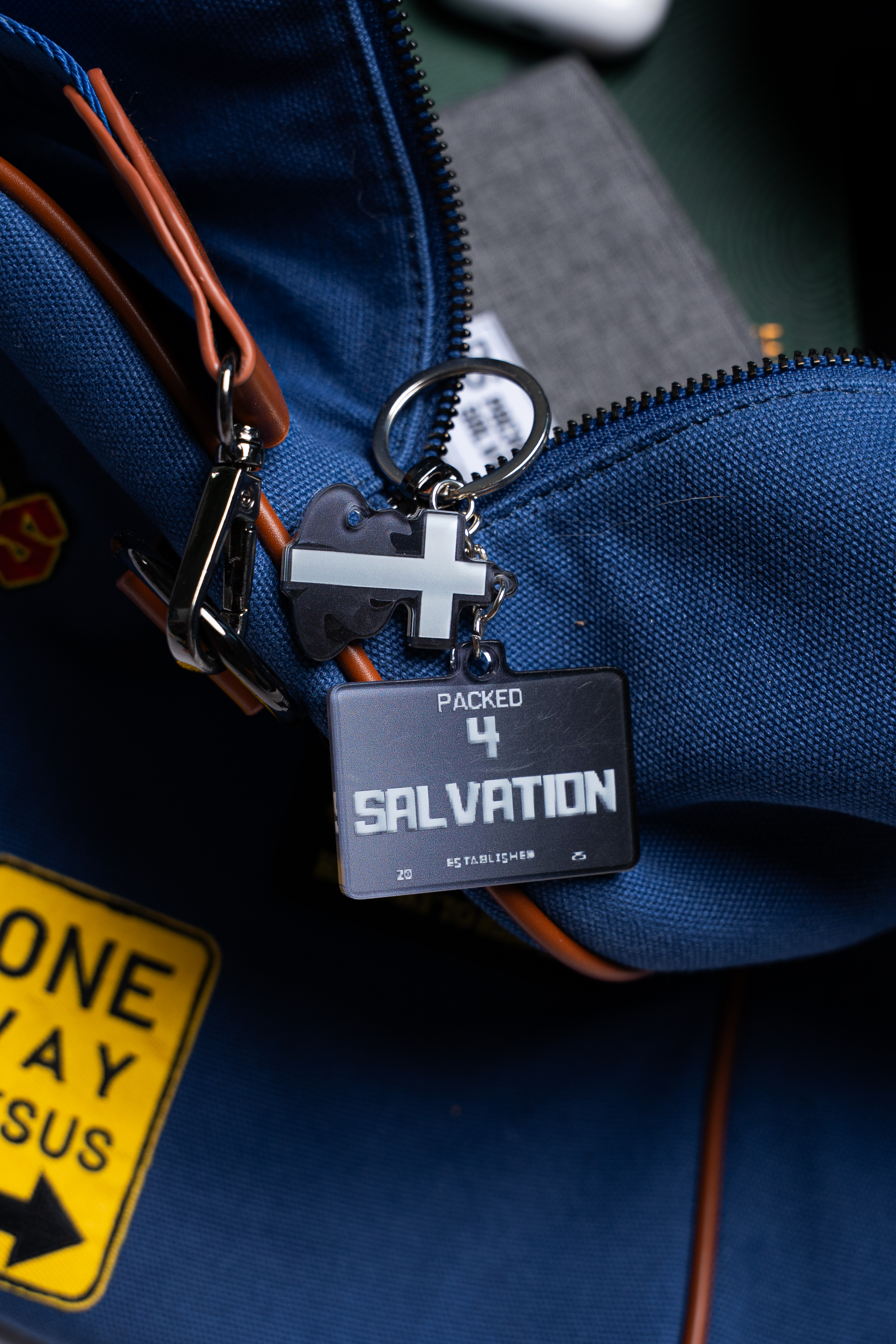 Blue bag with keychain reading 'Packed 4 Salvation' and cross symbol.