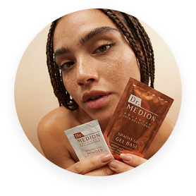 A woman with braided hair holds up two Dr. Medion skincare packets, a gel powder and a gel base.