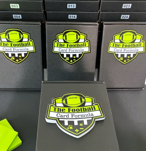 Black boxes with 'The Football Card Formula' logo featuring a football, in a stack.