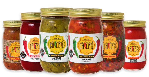 A lineup of six different jars of Hatch The Fresh Chile Co. salsa and other products.