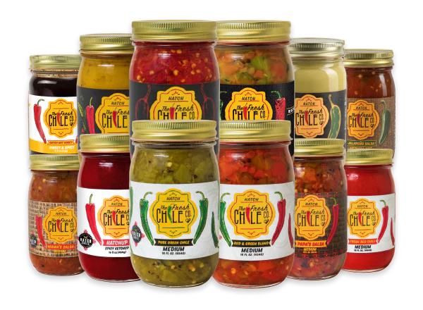 An assortment of Hatch The Fresh Chile Co. salsas, sauces, and relishes in glass jars.