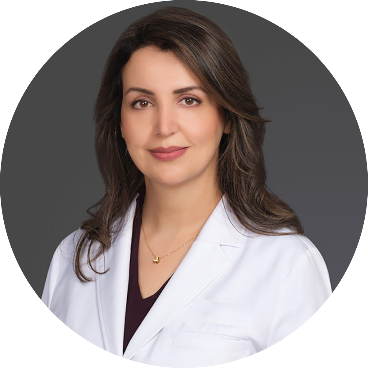 Person in a white coat against a gray background.