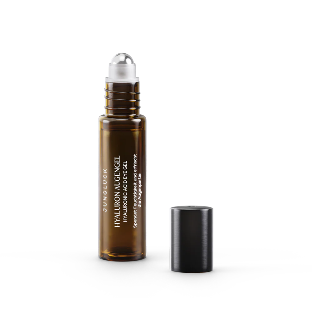 Close-up of a smiling person applying serum with a dropper on their face.