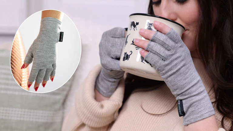 Person wearing gray gloves holding a cat-patterned mug.