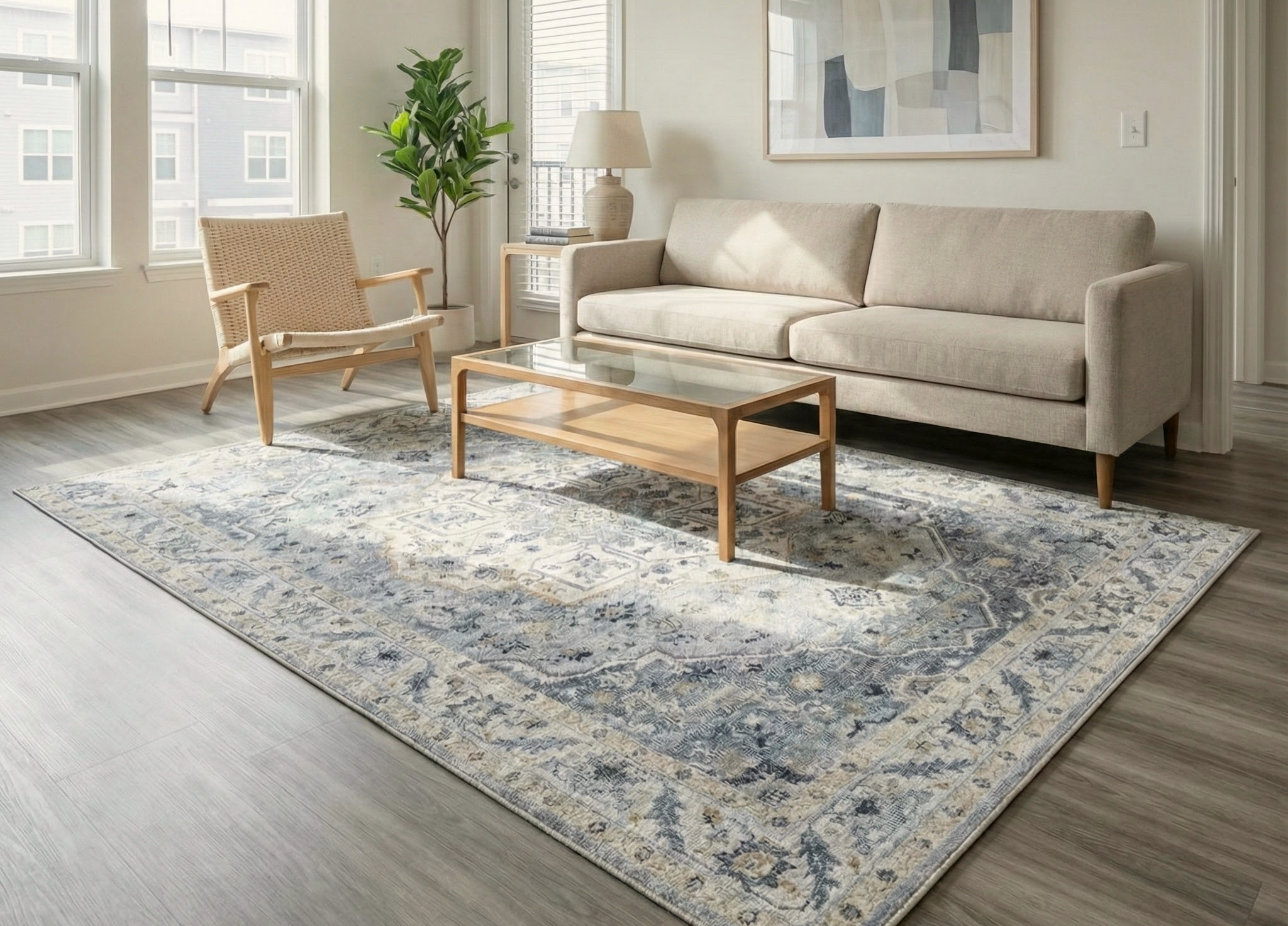 Modern living room with sofa, armchair, rug, and abstract wall art.