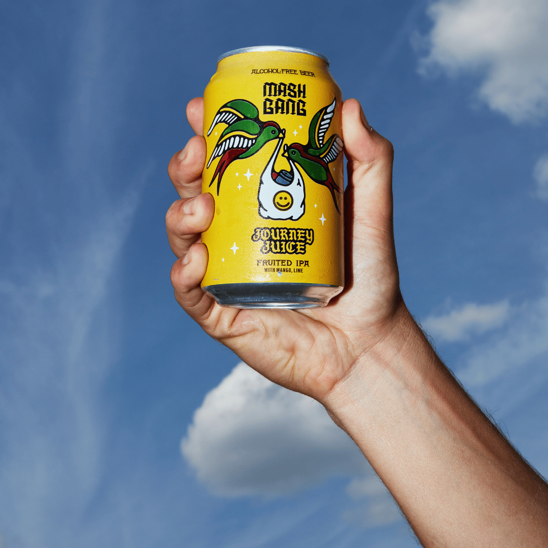 Hand holding a yellow can labeled 'Mash Gang Journey Juice' against a blue sky.