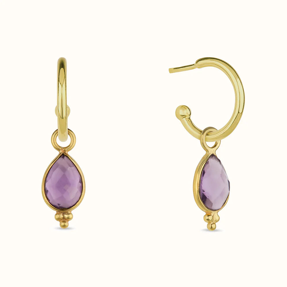 Gold hoop earrings with purple teardrop gemstones.