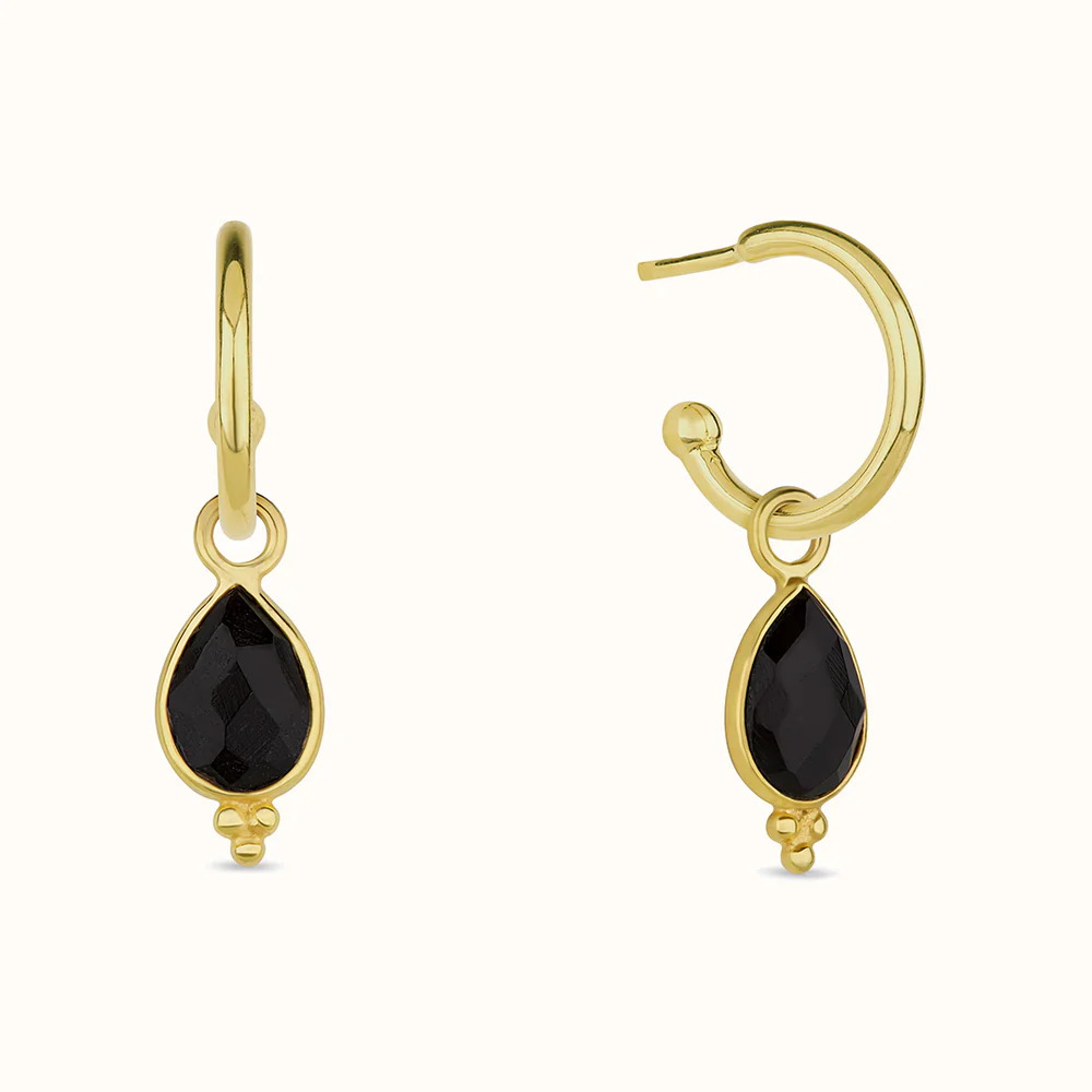 Gold earrings with black teardrop-shaped stones.