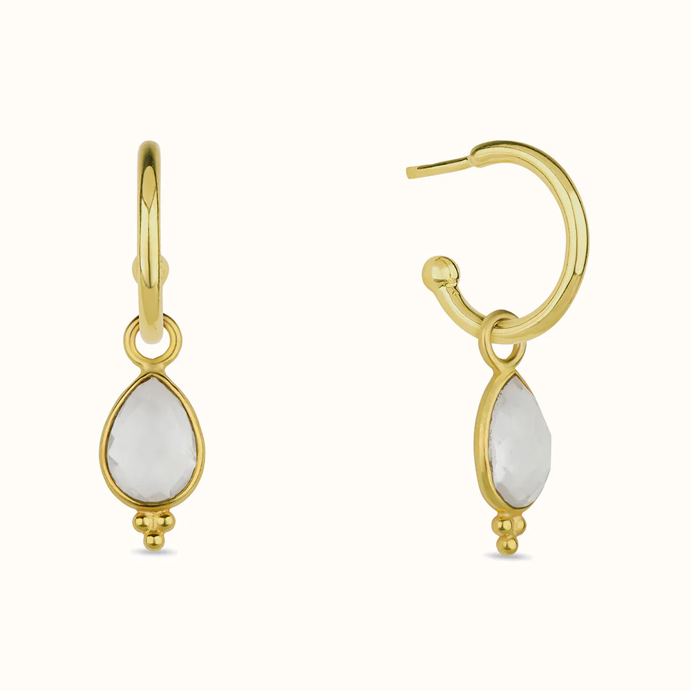 Two gold hoop earrings with teardrop-shaped white gemstones.
