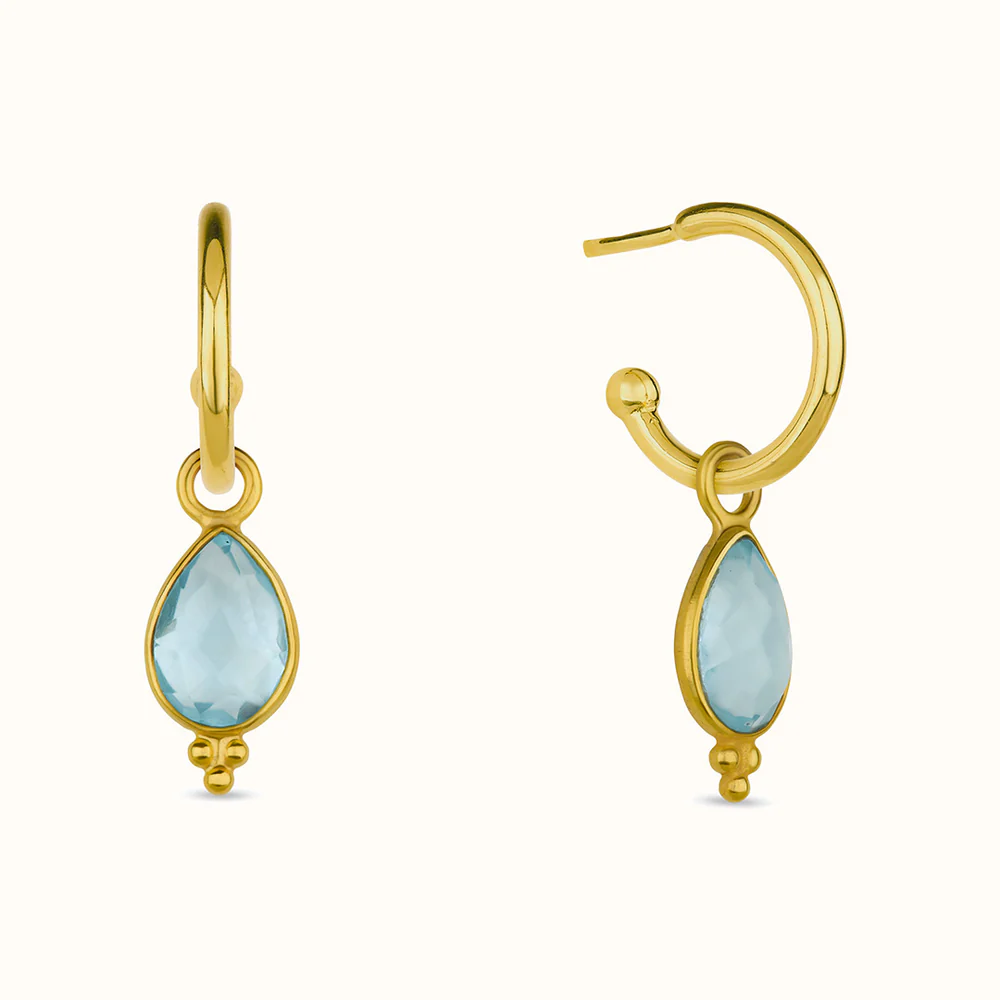 Gold hoop earrings with blue teardrop-shaped stones.