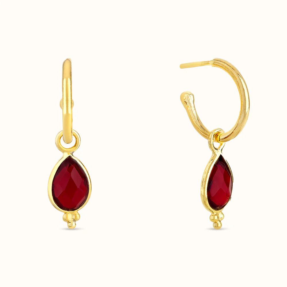 Gold hoop earrings with teardrop-shaped red gemstones.