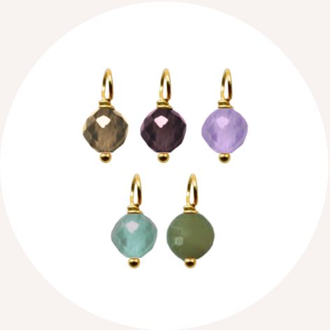 Five colorful gemstone charms with gold loops on a white background.