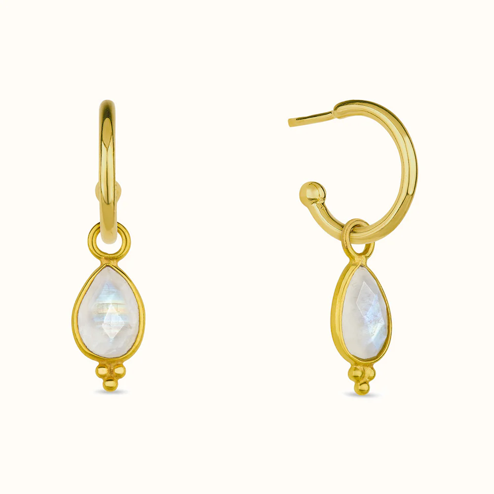 Two gold hoop earrings with teardrop-shaped gemstones.