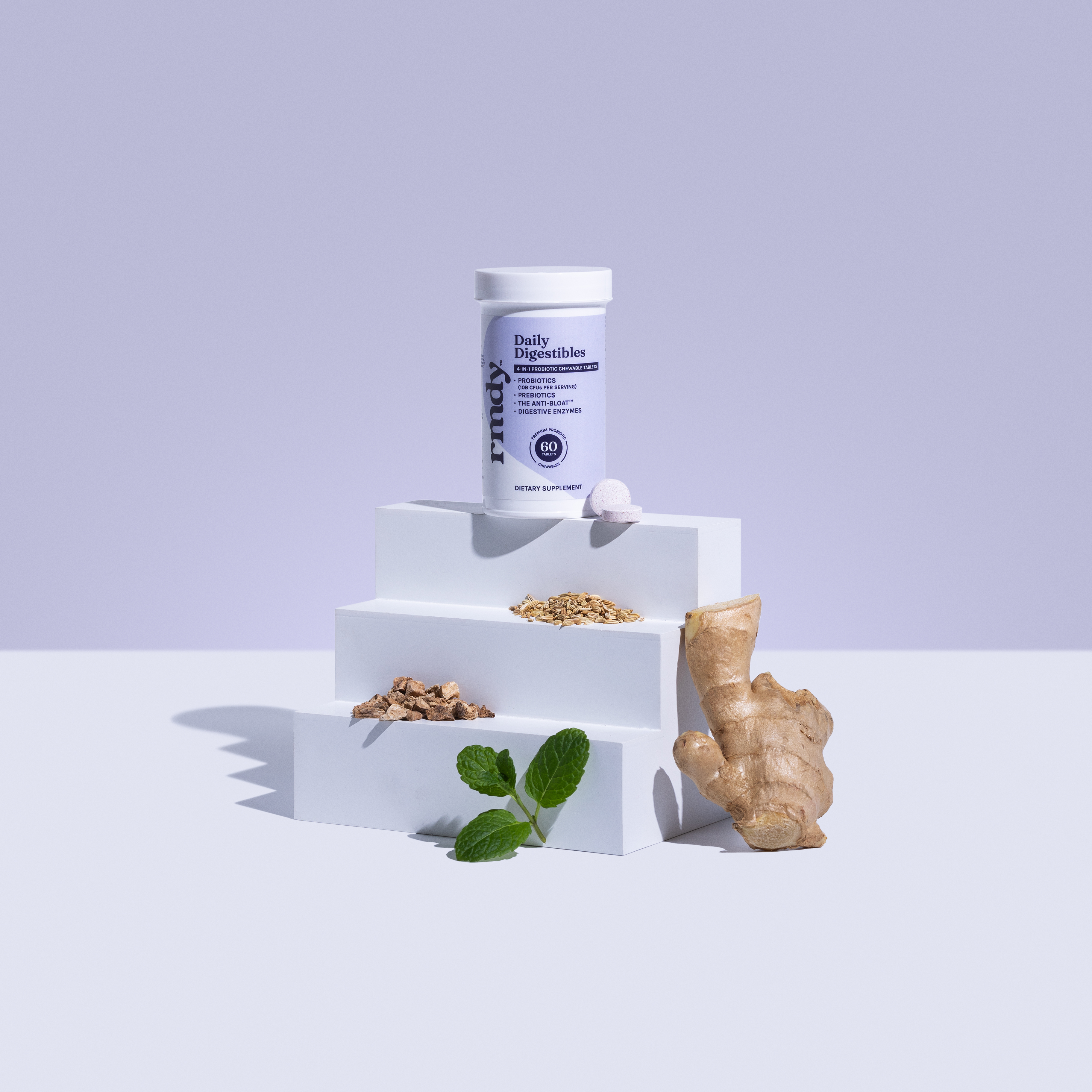 Supplement bottle on white steps with ginger, mint, and seeds.