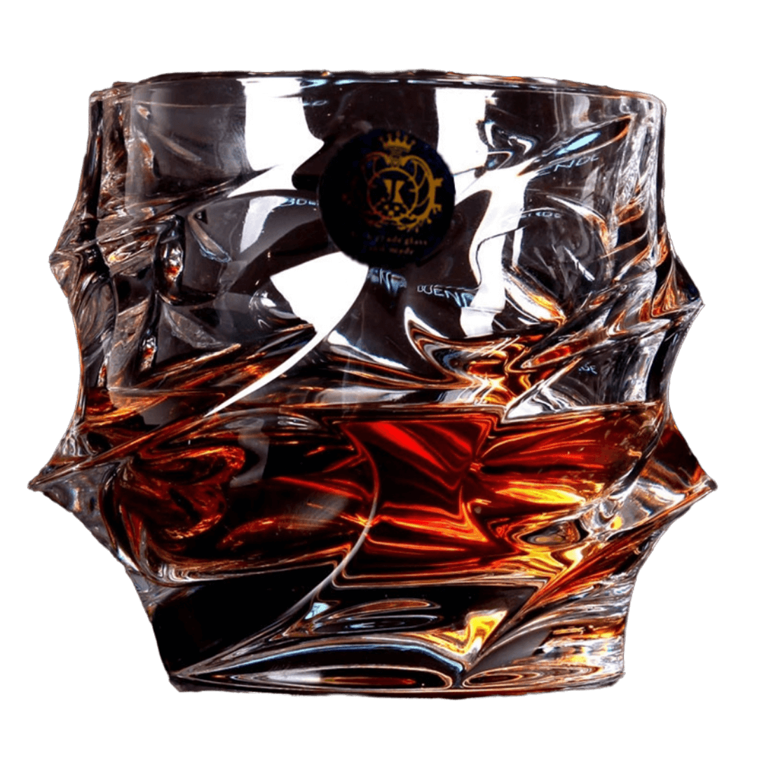 Intricately designed glass with amber liquid inside, set against a black background.